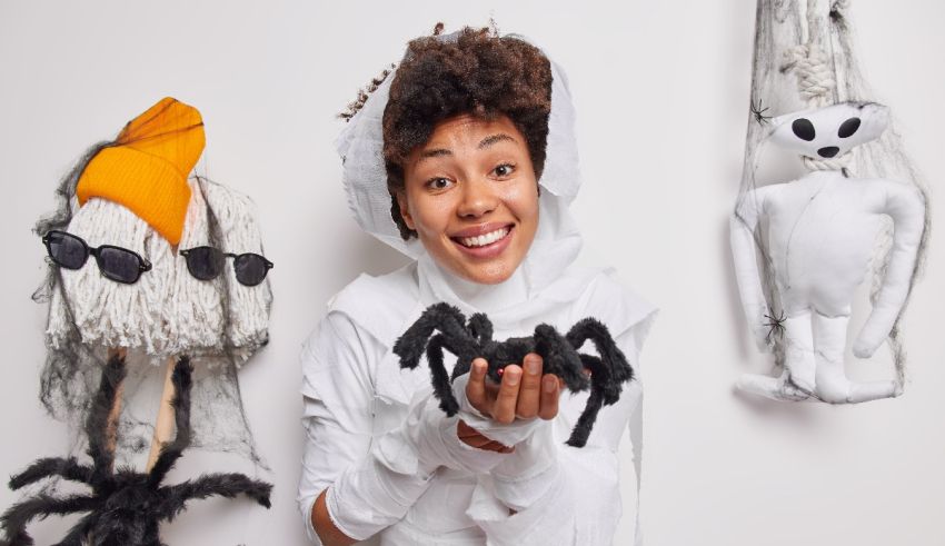 A woman dressed up in a halloween costume holding a spider and a spider.