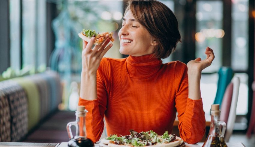 A woman eating a pizza in a restaurant.