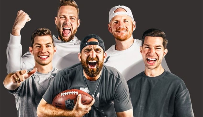 Four men are posing for a photo with a football.