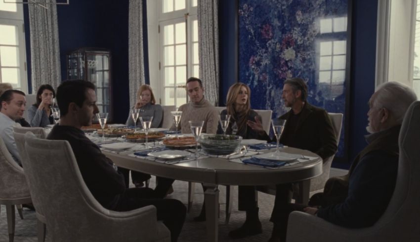 A group of people sitting around a table in a blue room.