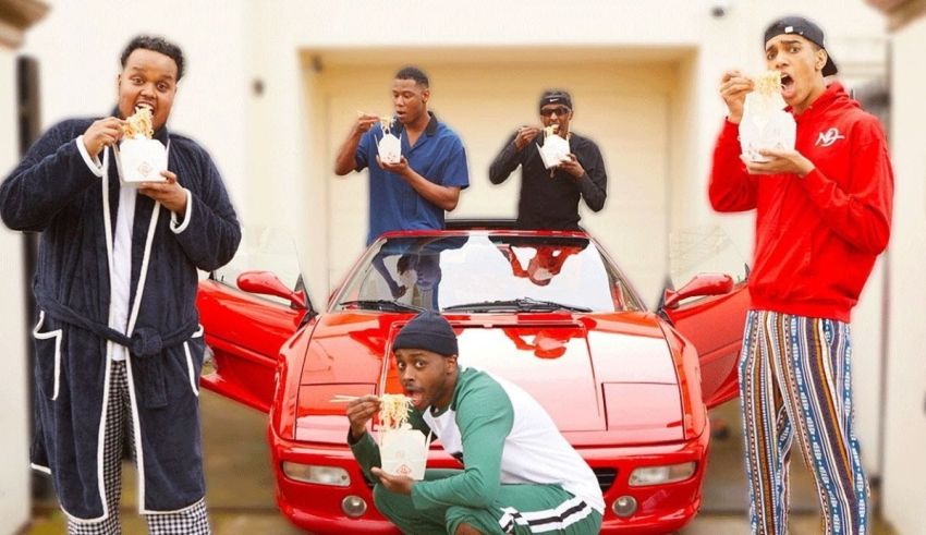 A group of men standing in front of a red sports car.