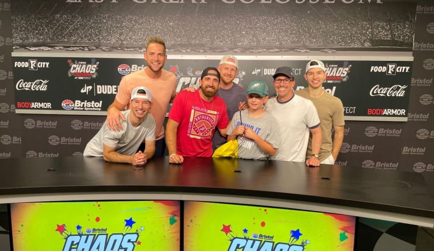 A group of people posing for a photo in front of a tv.