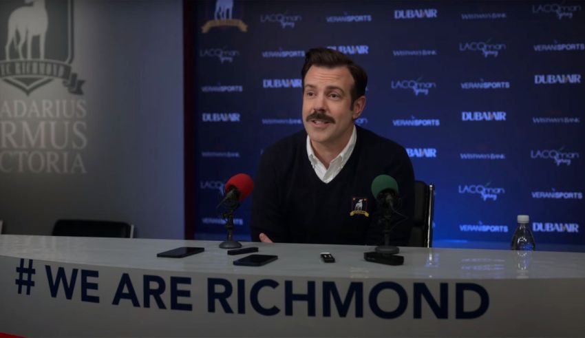 A man sitting in front of a microphone with the words we are richmond.