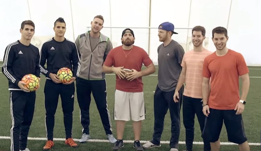 A group of men standing next to each other holding soccer balls.