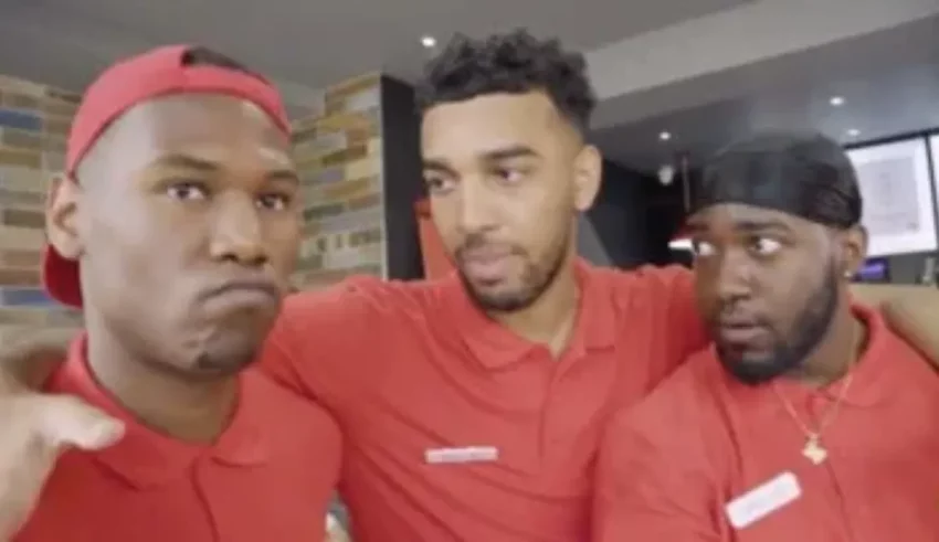 Three men in red shirts are posing for a picture.