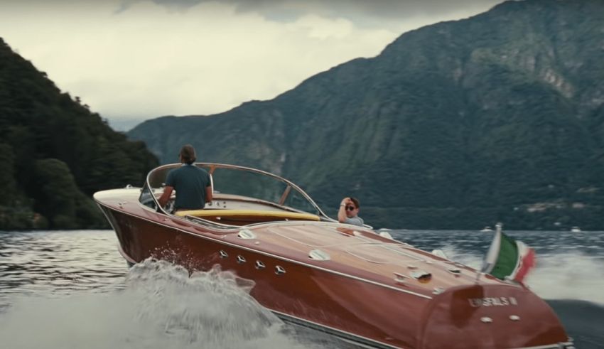 A man is driving a speed boat on a lake.