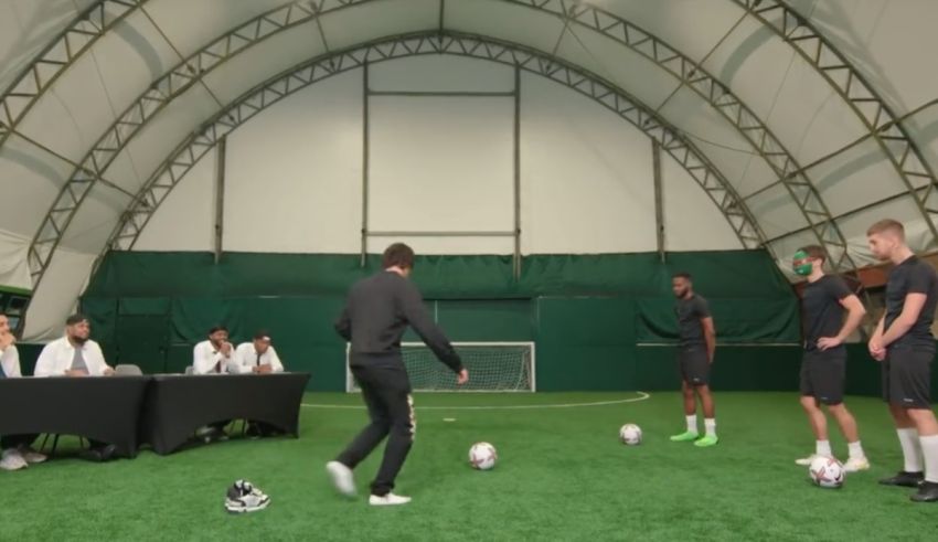 A group of men are playing soccer in a gym.