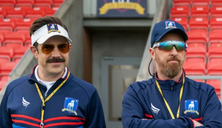 Two men standing next to each other in a stadium.