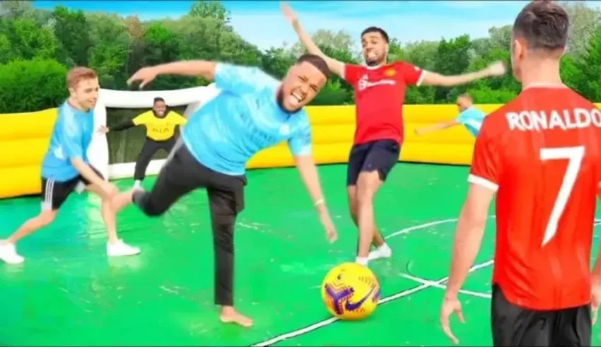 A group of men playing soccer on an inflatable soccer field.