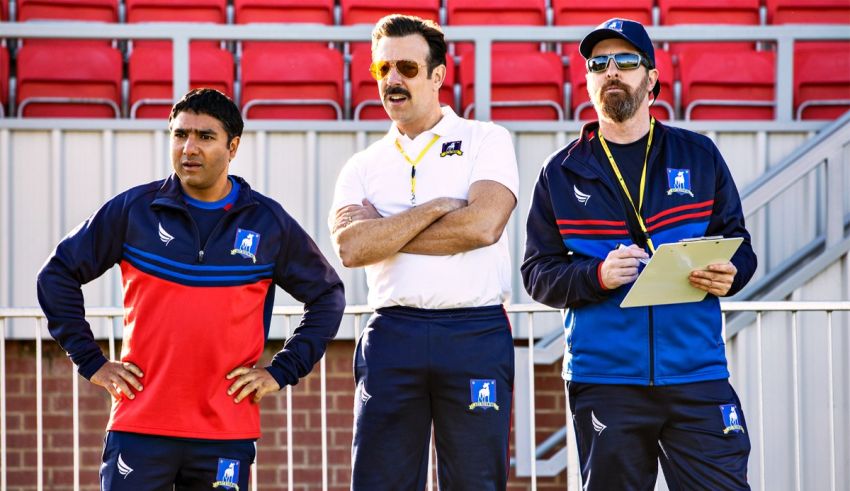 Three men standing next to each other in a stadium.