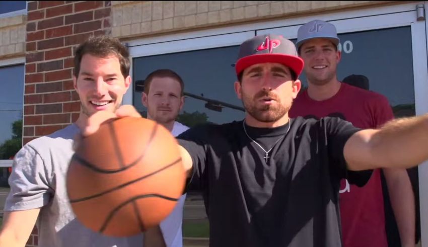 A group of men holding a basketball in front of a building.