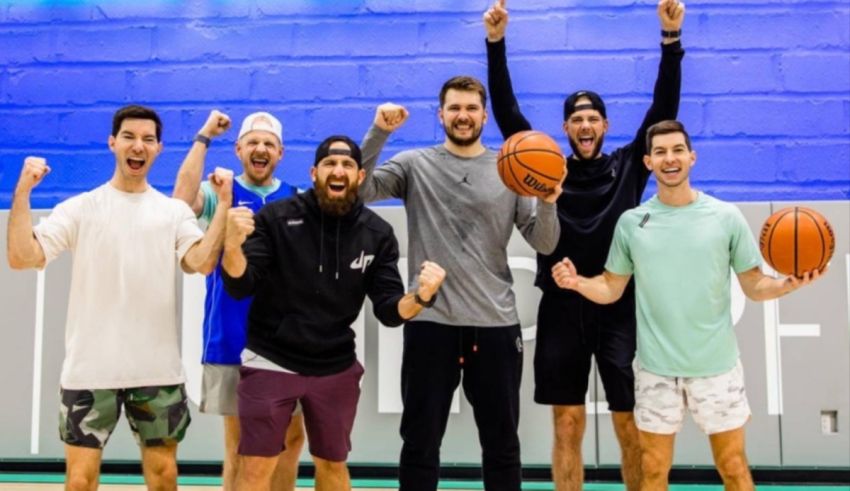 A group of men posing for a photo while holding basketballs.