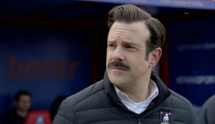 A man with a mustache is standing in the dugout.