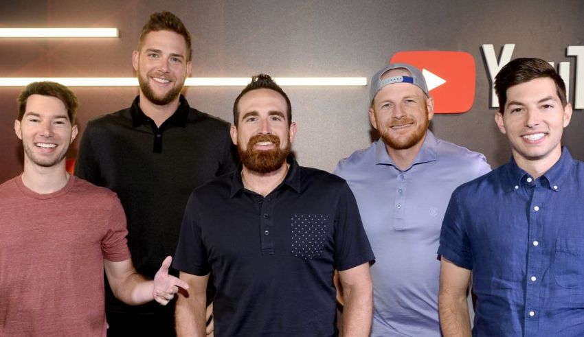 A group of men posing for a picture in front of a youtube sign.