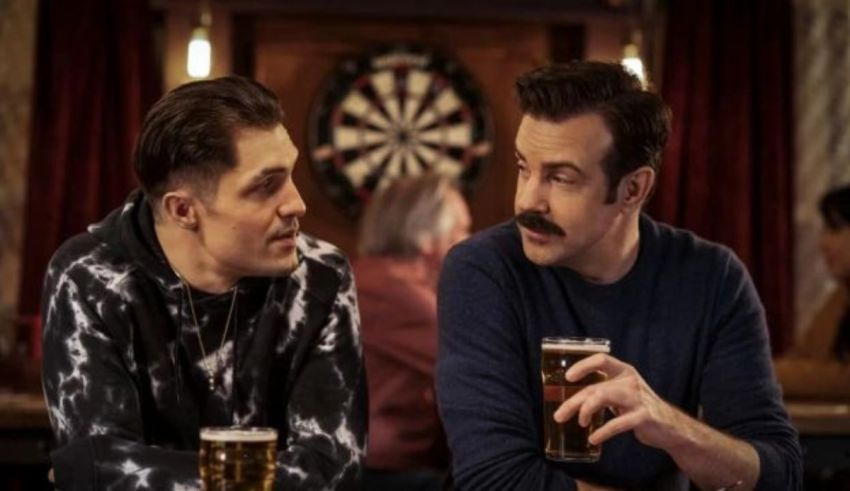 Two men sitting at a table drinking beer.