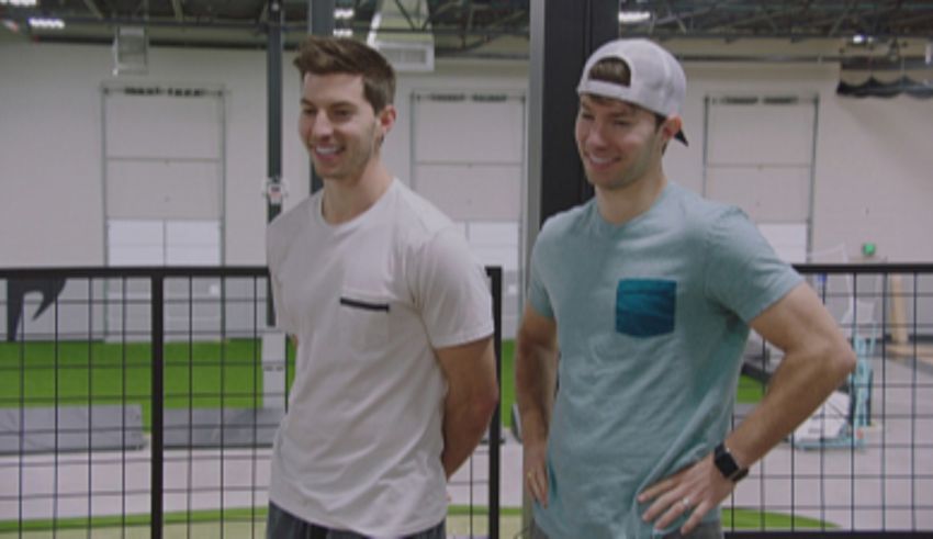 Two men standing next to each other in a gym.