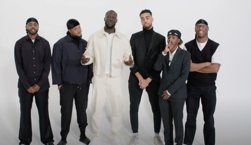 A group of men standing together in front of a white background.