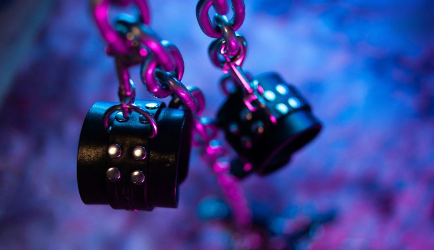 A pair of black chains hanging from a purple light.