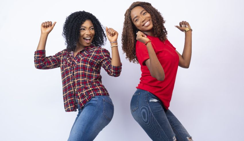 Two young african women dancing on a white background.