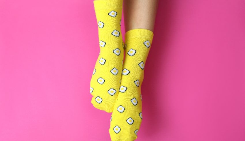 A woman wearing yellow socks on a pink background.
