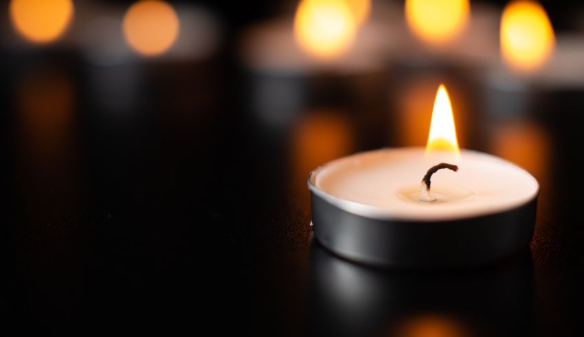 A group of lit candles on a black background.