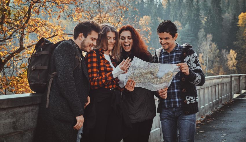 A group of friends looking at a map in autumn.