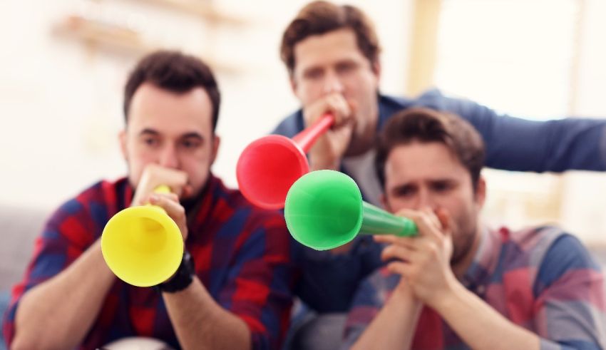 A group of men playing with colorful balloons on a couch.