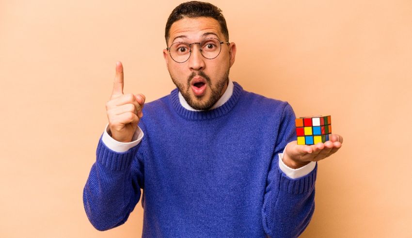 A man holding a rubik's cube and pointing his finger.