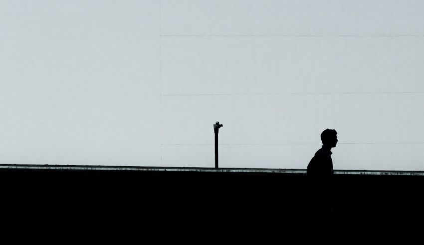 A silhouette of a man walking down a street.
