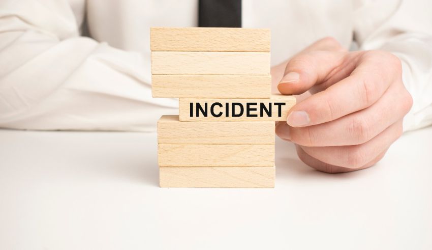 A man holding a wooden block with the word incident on it.