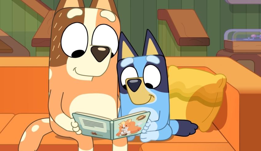 Two cartoon dogs reading a book on an orange couch.