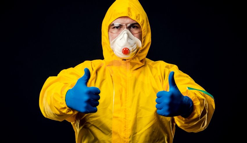 A man in a yellow protective suit giving a thumbs up.