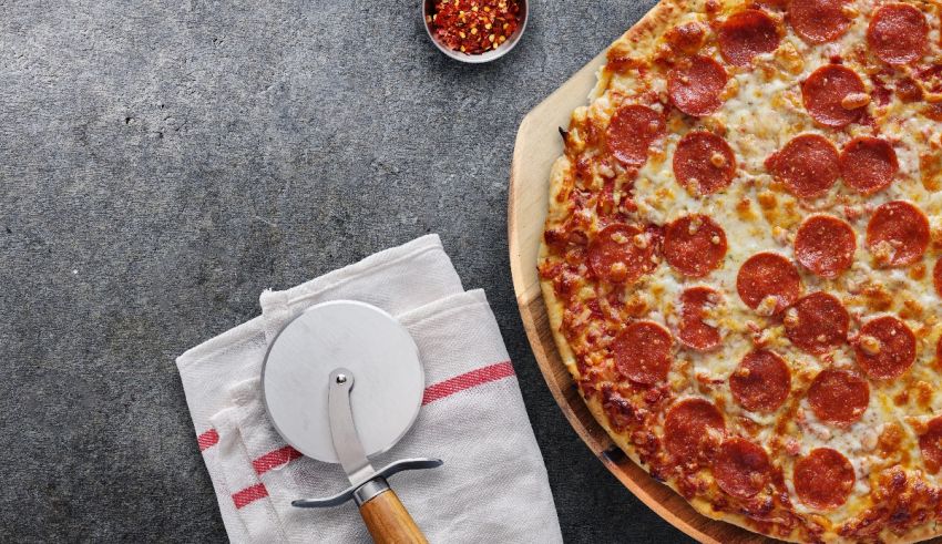 A pepperoni pizza on a wooden cutting board.