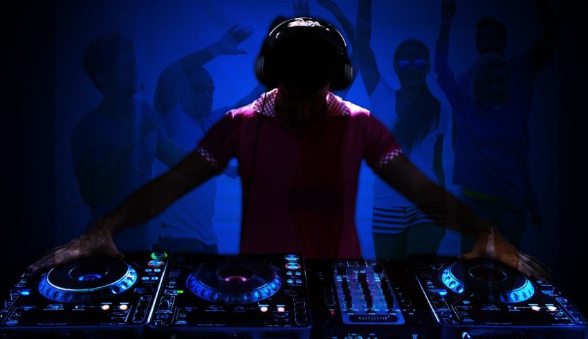 A dj is playing music in front of a crowd of people.