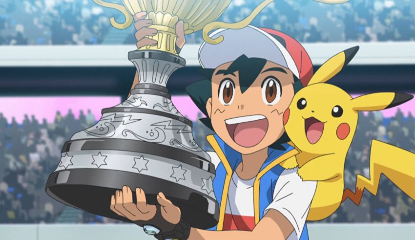 A boy holding up a pokemon trophy in front of a stadium.