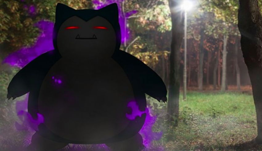 A black and purple pokemon standing in the woods.