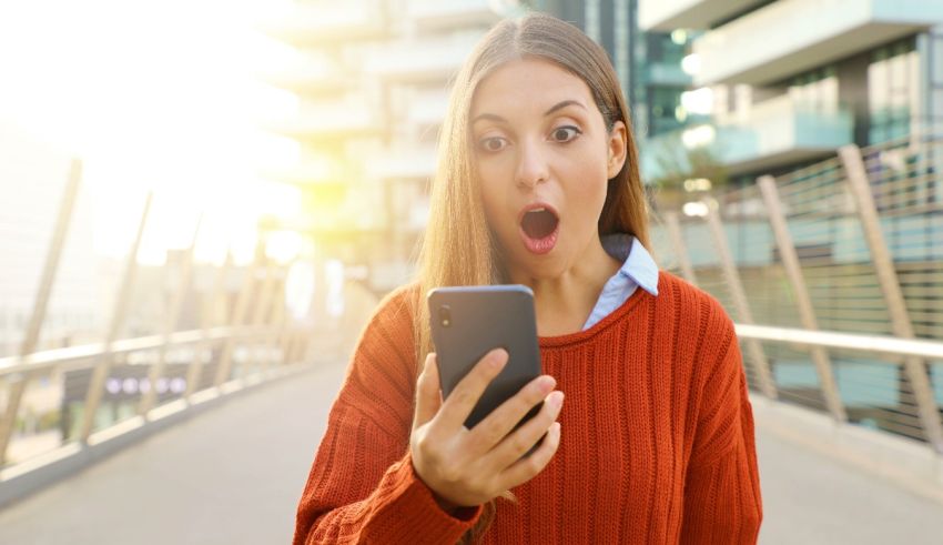 A woman with a surprised face looking at her phone.