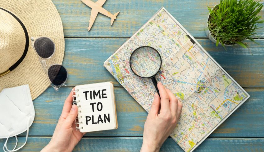 A woman holding a magnifying glass and a time to plan book on a wooden table.