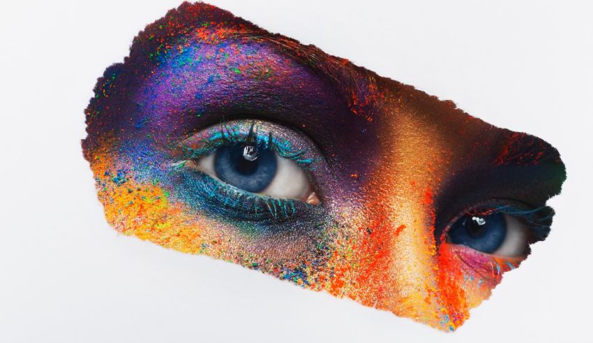 A woman's face with colorful makeup on a piece of paper.