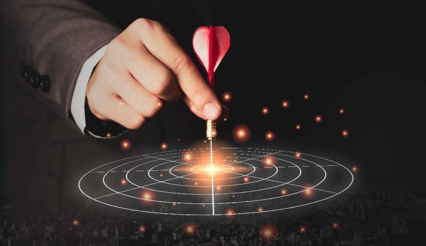 A businessman is pointing at a heart shaped target on a map.