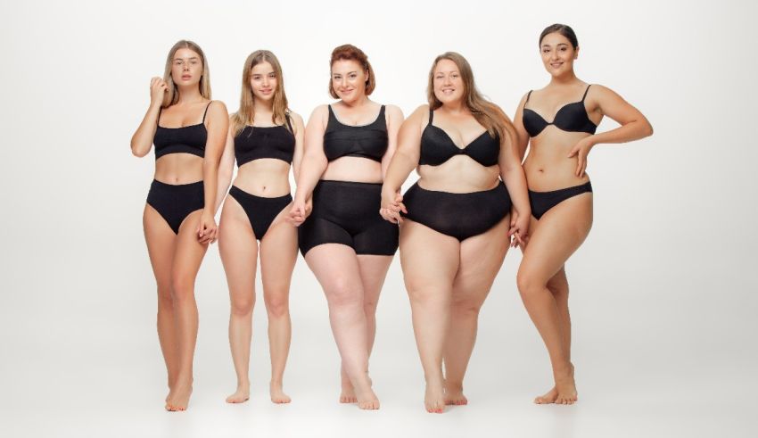 A group of women in black lingerie standing in front of a white background.