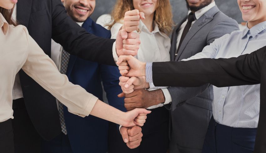 A group of business people holding hands together.