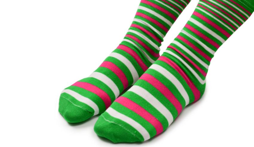 A pair of green and pink striped socks on a white background.
