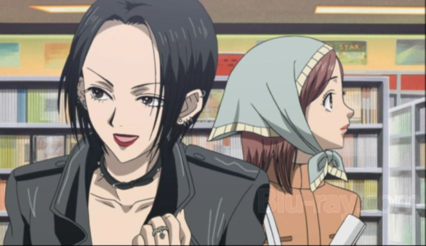 Two anime characters standing next to each other in a library.