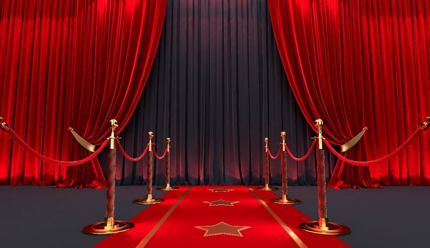 A red carpet and red ropes in front of a red curtain.