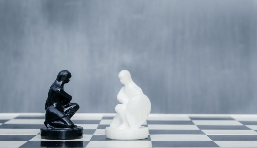 Two black and white chess pieces on a chess board.