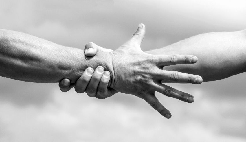 A black and white photo of two people shaking hands.