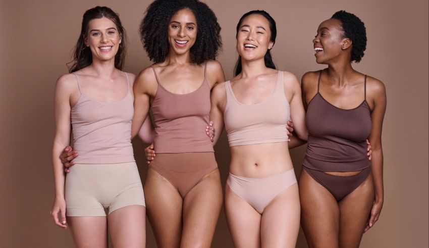 Four women in nude underwear posing for a photo.
