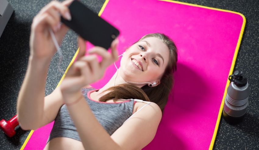 A woman is taking a selfie on a pink mat.