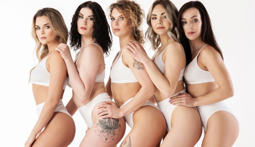 A group of women in white bikinis posing for a photo.